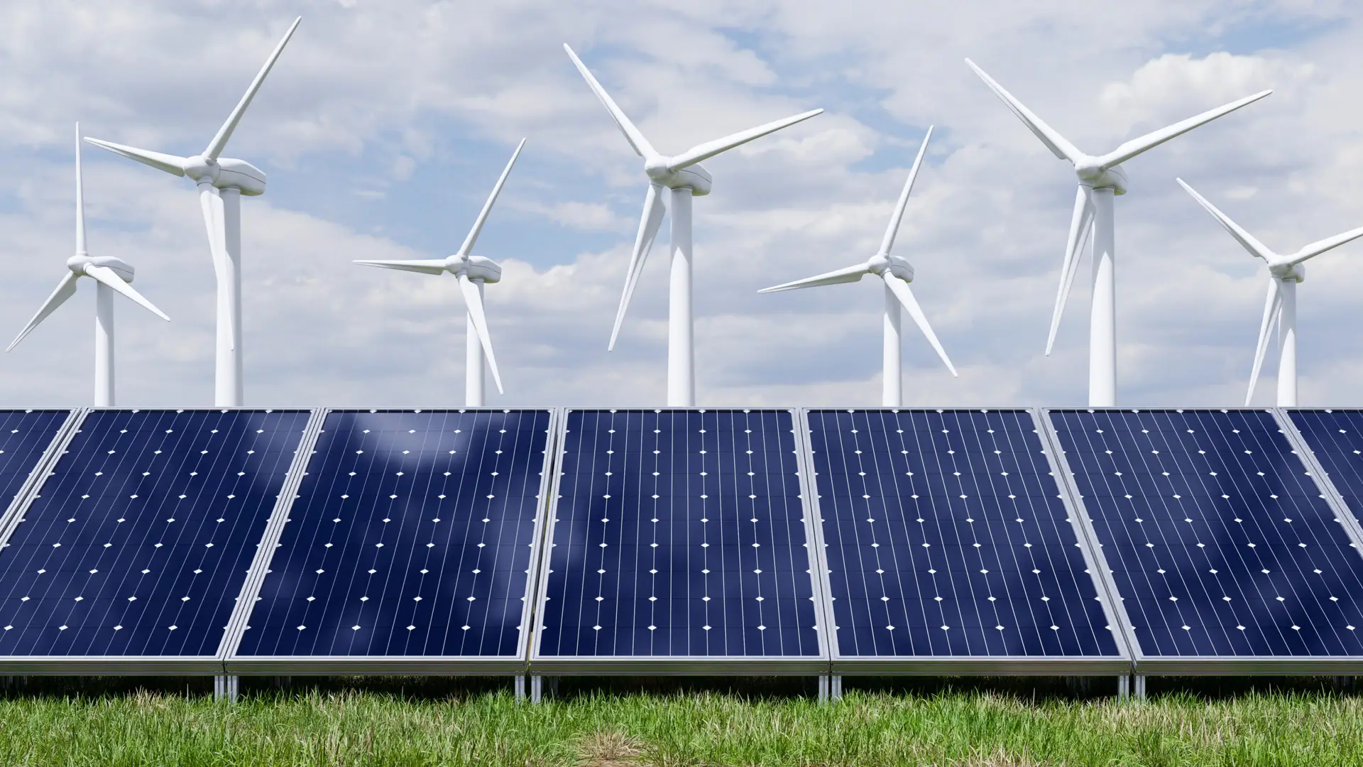 Solarpanels und Windrad vor blauem Himmel